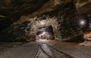Underground mining truck with FOG-based inertial navigation system maintaining sub-degree accuracy in high-vibration mining environments, preventing collisions in narrow tunnels.